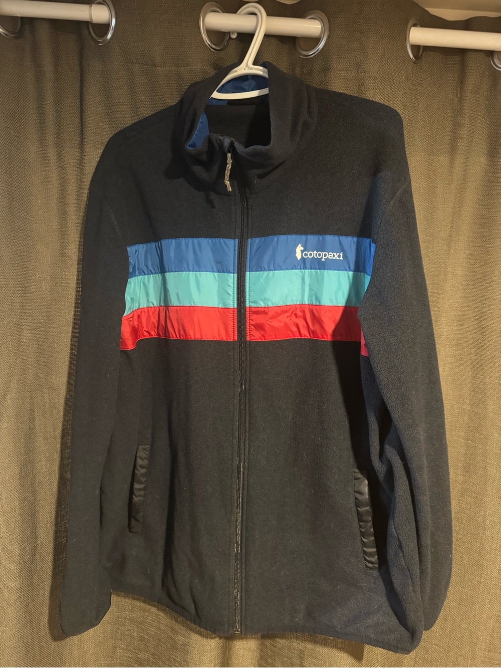 cotopaxi Black Jacket with Blue, Teal & Red Stripe Chest